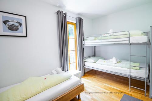 a room with two bunk beds and a window at Schönblick Mountain Resort & Spa - Das Original! in Rauris