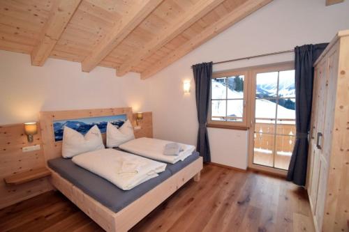 een slaapkamer met een bed en een groot raam bij Ferienwohnung "Panoramablick" WILD603 FeWo-PLANcom in Auffach