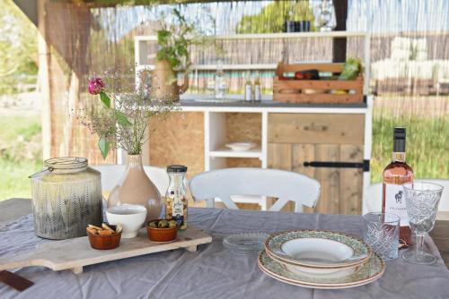 a table with plates and a bottle of wine on it at Smuk Lytse Bell Tent in Echtenerbrug