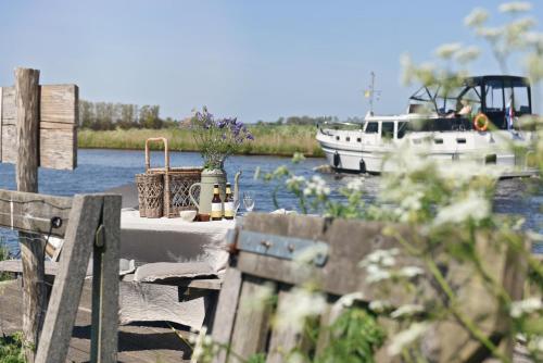 a table with a boat in the water with a tableablish at Smuk Lytse Bell Tent in Echtenerbrug