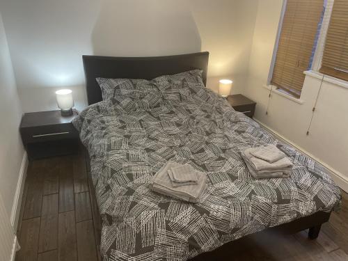 a bedroom with a bed with two towels on it at Beautiful apartment right off of Broadway Market in London