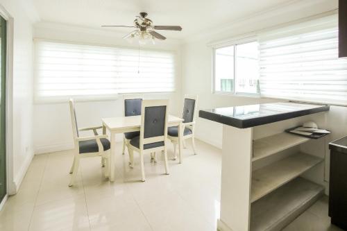 a white kitchen with a dining table and chairs at Hotel Euroasia By BLUEBOOKERS in Angeles