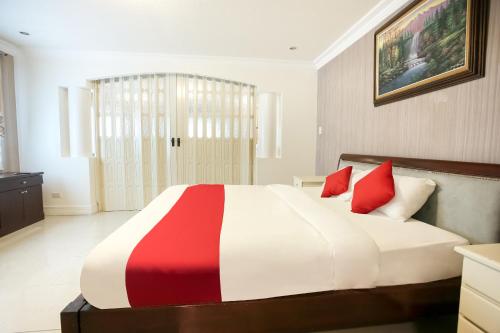 a bedroom with a large bed with red pillows at Hotel Euroasia By BLUEBOOKERS in Angeles
