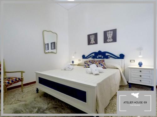 a bedroom with a white bed and a mirror at Atelier House 69 in Trappeto