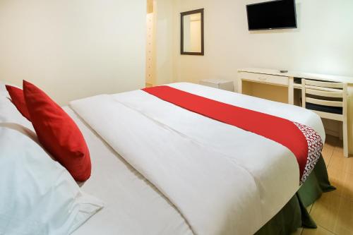 a bedroom with a large bed with red pillows at Hotel Euroasia By BLUEBOOKERS in Angeles