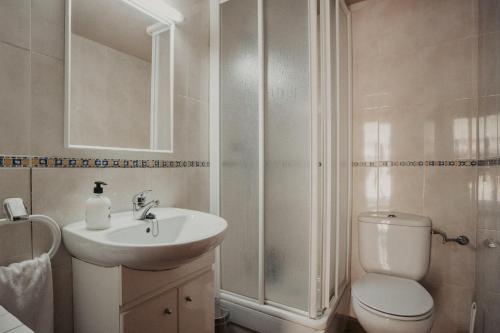 a bathroom with a toilet and a sink and a shower at Subirana Rural in Les Llosses