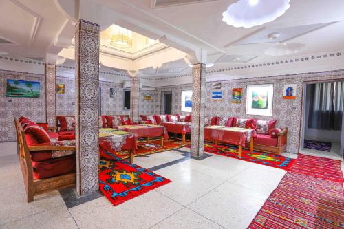 ein Restaurant mit roten Stühlen und Tischen in einem Zimmer in der Unterkunft The Rina Hostel in Agadir