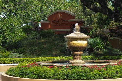 ポルトープランスにあるHotel Royal Oasisの背景の看板のある庭の噴水