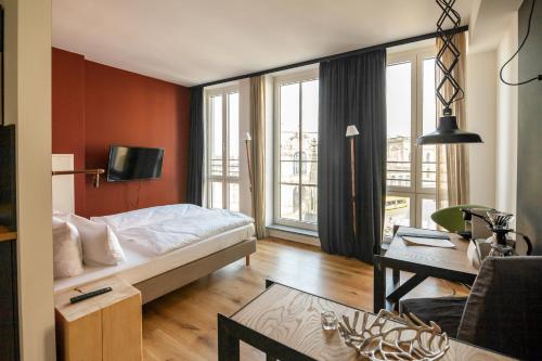 a hotel room with a bed and a living room with at Staycity Aparthotels Dresden City Centre in Dresden