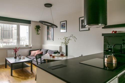 een keuken en een woonkamer met een bank en een tafel bij Apartament Złota in Warschau