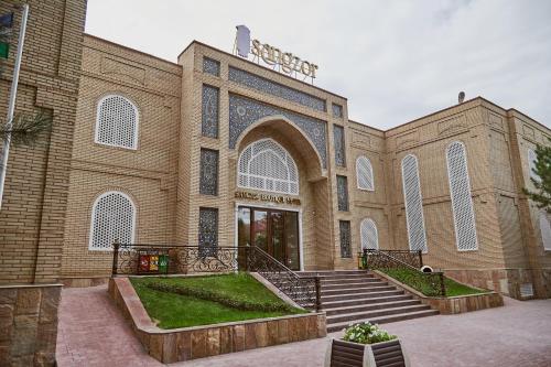 um grande edifício de tijolos com escadas em frente em Sangzor Boutique Hotel em Samarkand