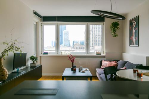 a living room with a couch and a window at Apartament Złota in Warsaw