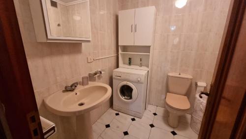 ein Badezimmer mit einem Waschbecken und einer Waschmaschine in der Unterkunft Soleado piso 4 habit a pie de playa Sanxenxo in Sanxenxo