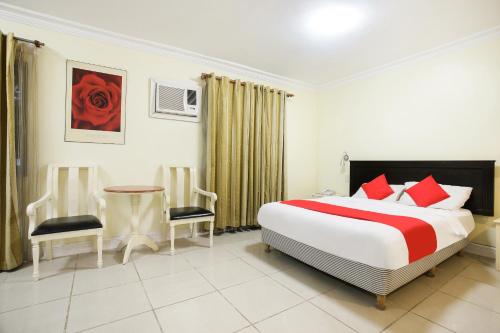 a bedroom with a bed and a table and chairs at Hotel Euroasia By BLUEBOOKERS in Angeles