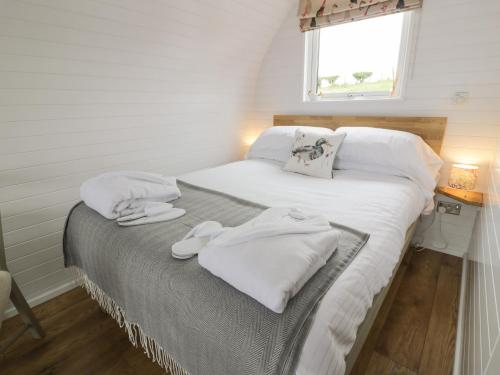 a bedroom with a bed with white towels on it at Laird Lodge 4 in Lockerbie