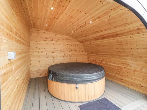 a wooden sauna with a large barrel in the middle at Laird Lodge 3 in Lockerbie