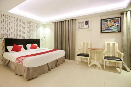 a hotel room with a bed and a table and chairs at Hotel Euroasia By BLUEBOOKERS in Angeles