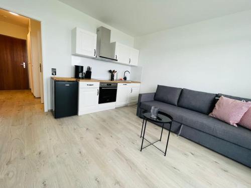 a living room with a couch and a table and a kitchen at Apartment Diekblk mit Pool in Dahme