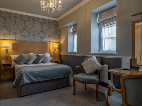 a bedroom with a bed and a desk and a chair at The Bulkeley Hotel in Beaumaris