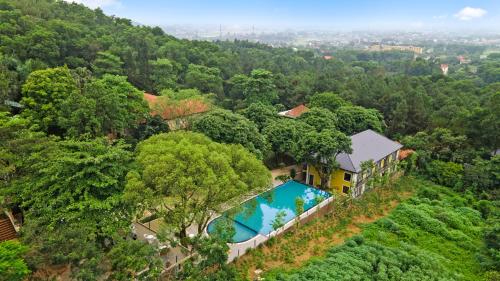 an aerial view of a house with a swimming pool in the forest at Cerf Volant Soc Son in Hanoi