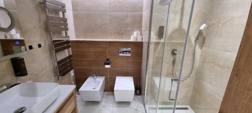 a bathroom with two toilets and a shower and a sink at Apartmán GOLD Akvamarín in Bešeňová