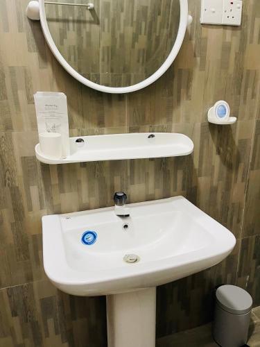 a bathroom with a white sink and a mirror at Ratnam Hotel Jaffna in Jaffna