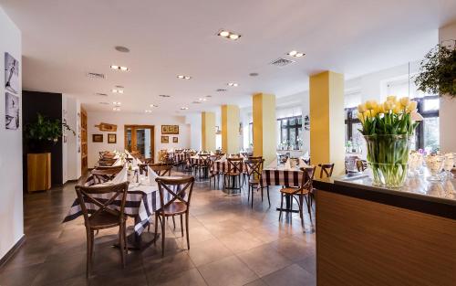 jadalnia ze stołami i krzesłami w restauracji w obiekcie Boutique Eco Hotel Sasanka w Szklarskiej Porębie