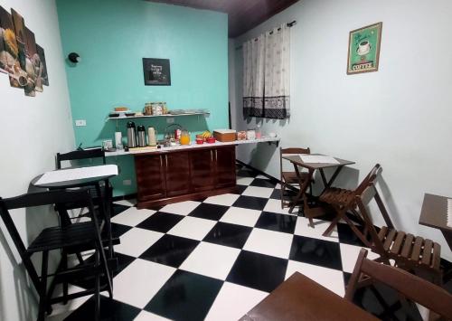 Zimmer mit kariertem Boden sowie Tischen und Stühlen in der Unterkunft Hotel Serra do Mar in Paranaguá