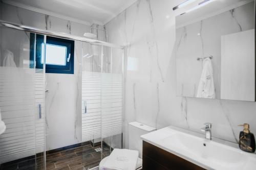 a white bathroom with a sink and a shower at ALEXANDRA Boutique Residence Downtown in Alexandroupoli