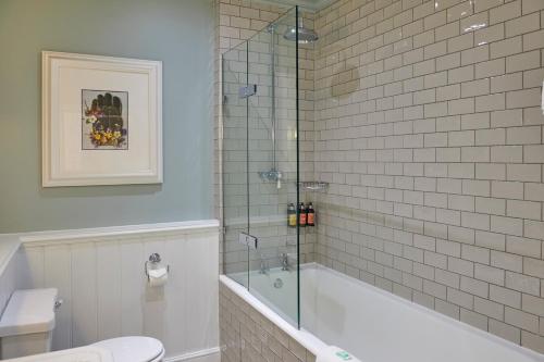 a bathroom with a shower and a tub and a toilet at Hotel du Vin Winchester in Winchester