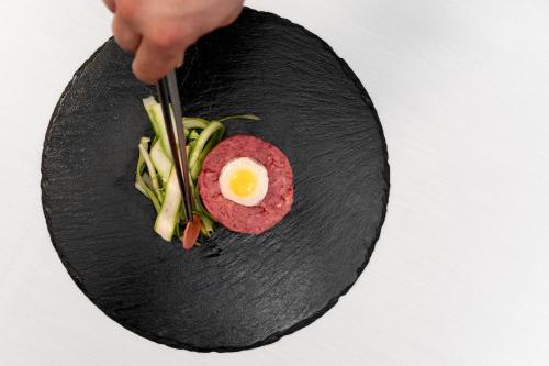 a person holding a plate of food with an egg on it at Hotel Minerva in Arezzo