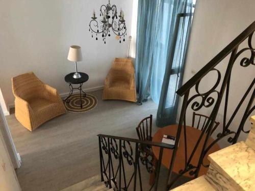 a living room with a chair and a chandelier at La Casa de Tente in Priego de Córdoba