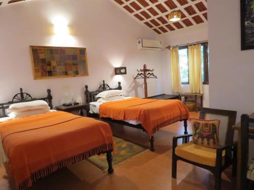 a bedroom with two beds and a cross on the wall at Kanha Jungle Lodge in Dhanwār