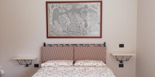 a bedroom with a bed with a picture above it at Il Poggio degli Antichi Sapori - Residence in Paternopoli