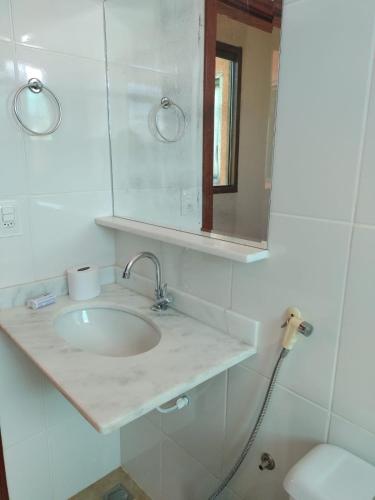 a bathroom with a sink and a mirror and a toilet at Pousada Mangaba da Serra in Serra do Cipo