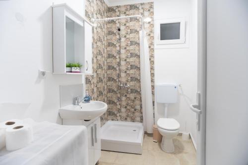 uma casa de banho branca com um lavatório e um WC em Panorama Apartments em Gevgelija