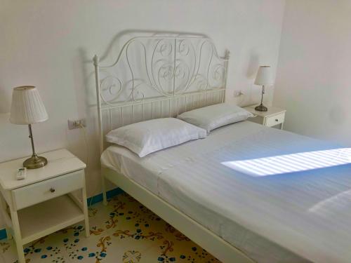 1 dormitorio con 1 cama blanca y 2 mesitas de noche en Tenuta Amalthea, en Sessa Aurunca