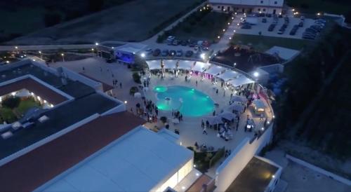 a group of people standing around a pool at night at Tenuta Amalthea in Sessa Aurunca