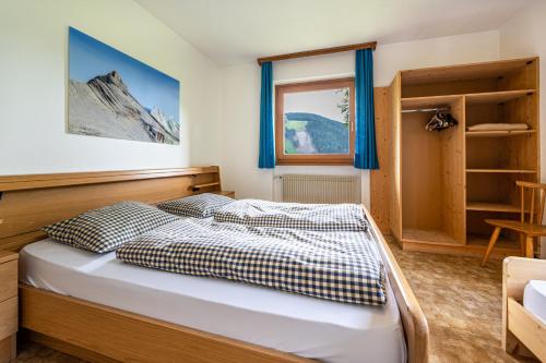 een slaapkamer met een bed en een raam bij Ciasa La Palsa App 2 in San Vigilio Di Marebbe