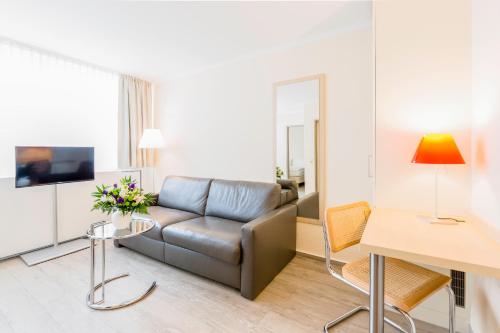 a living room with a couch and a table at Michels Thalasso Hotel Nordseehaus in Norderney