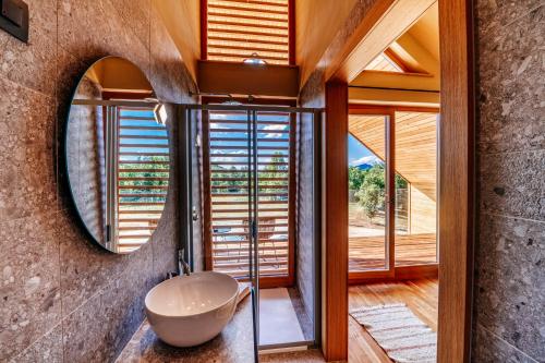 a bathroom with a round mirror and a sink at Villa Lovelos in Lovinac