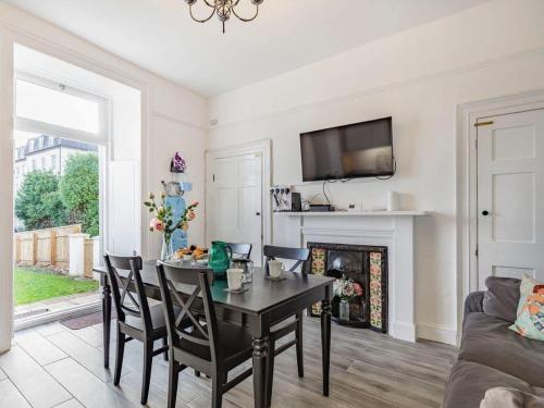 a living room with a table and a fireplace at Lovely Heather House 2 king 1 double 2 single beds in Torquay