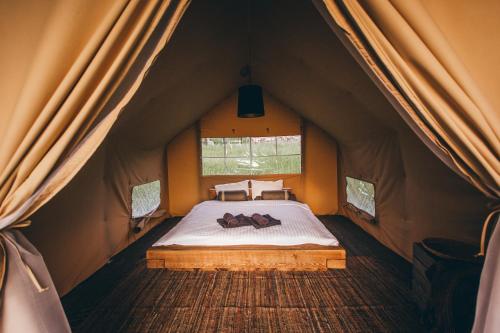 a bed in a tent with two people laying on it at Muuski glempings in Korneti