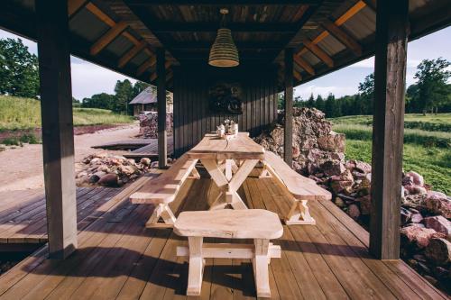 a wooden table and benches on a wooden deck at Muuski glempings in Korneti