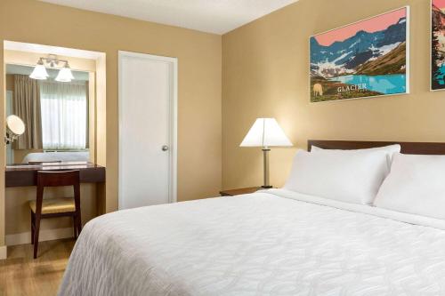 a bedroom with a bed and a desk and a bed sidx sidx sidx at Travelodge by Wyndham Presidio San Francisco in San Francisco