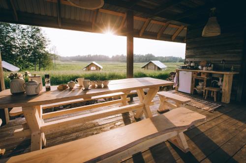 duży drewniany stół na środku patio w obiekcie Muuski glempings w mieście Korneti