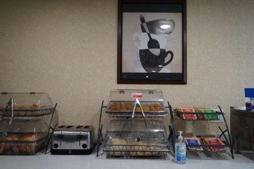 a table with trays of pastries and a picture on the wall at Baymont by Wyndham Bridgeport/Frankenmuth in Bridgeport