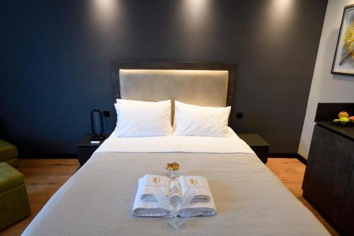 a hotel room with a bed with two books on it at Living Rooms in Skopje