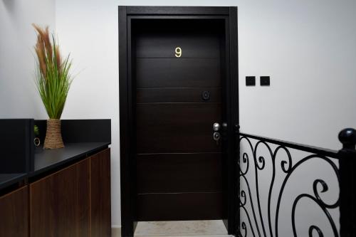 a black door with a gold number on it at Living Rooms in Skopje
