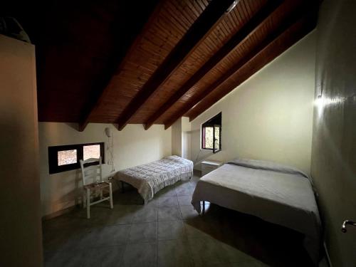 a bedroom with two beds and a chair in a room at Green Coast Villa - Tragjas Village in Vlorë